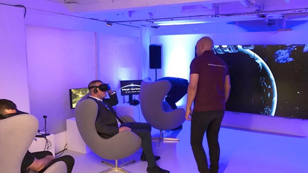 Zwei Personen erleben Magic Horizons Virtual Reality in einem abgedunkelten Raum