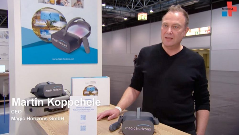 Zwei Personen stehen an einem Tisch mit einer Magic Horizons Virtual-Reality-Brille und führen ein Interview